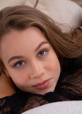 Игривая детка ласкает бритую киску на диване