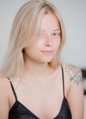 Молоденькая девка снимает пеньюар сидя на кровати