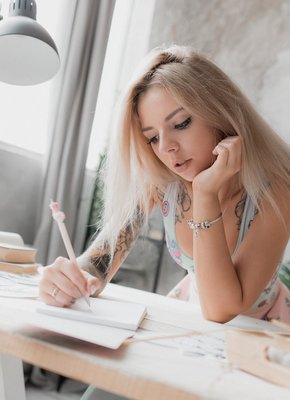 Милая девка в татуировках эротично задирает юбку